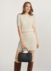 Black leather women's handbag TORES-1156-99(Z25), view of the product in the model's hand on a light background.
