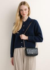 Small black glossy crossbody bag TOREC-1254-9F(Z26); angled view of the product on a model. Half of the figure is visible.
