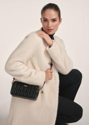 Classic black women's handbag TOREC-1103-99(Z25) - front view of the product on a model against a white background. Half of the silhouette visible.