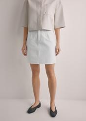 Cream denim mini skirt SPCDT-0126-0B(W26), front view of the product on the model. Half of the silhouette visible.