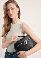 Black round women's cosmetic bag TOREC-0919B-99(Z25), view of the product in the model's hands. Half of the silhouette visible.