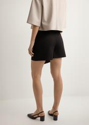 Women's black culottes SZODT-0008-99(W26), back view of the product on the model. Half of the silhouette visible.