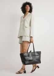 Large brown leather women's handbag TORES-1299-1H(W26) - front view of the product, held by the model, against a white background. Full body silhouette visible.