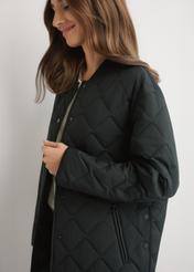 Women's black quilted jacket KURDT-0580-99(W26) - side view of the product, on a model, against a light background. Half of the silhouette visible.