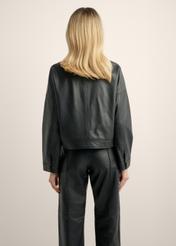 Women's short black leather jacket KURDS-0629-99(Z26), back view of the product on the model. Half of the silhouette visible.