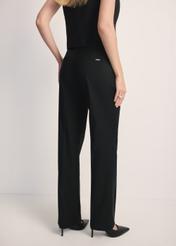 Black women's trousers with a crease SPODT-0114-99(Z25), product visible from the back on the model, half of the silhouette visible.
