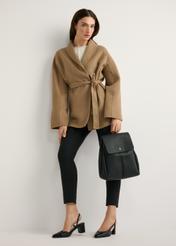 Black medium women's backpack TOREC-1132-99(W26) - front view of the product, held by the model, against a light background. The entire silhouette is visible.