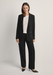 Black elegant women's trousers SPODT-0106A-99(W26), product view from the front on the model, the entire silhouette is visible.