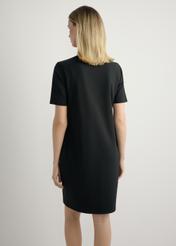 Black cotton dress SUKDT-0185A-99(W26), back view of the product on the model. Half of the silhouette visible.