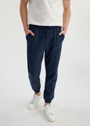 Navy blue men's sweatpants SPOMT-0109-69(W25) - front view on model on white background. Half of the silhouette visible.