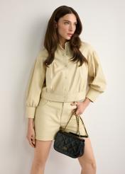 Black patent leather women's handbag TORES-1297-99(W26), product view in model's hand. Half of silhouette visible.