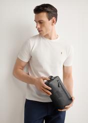 Black leather men's cosmetic bag TORMS-0528-99(Z26) - front view of the product, held by the model, against a light background. Half-length silhouette visible.