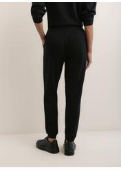 Women's black trousers SPODT-0108-99(W26), view of the product from the back of the model. Half of the silhouette visible.