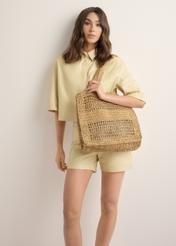 Women's straw handbag in natural beige TOREC-1221-1E(W26), product view on model's shoulder. Full body visible.