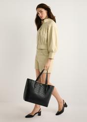 Black monogram shopper bag TOREC-1181-99(W26) - front view of the product, on a model, against a light background. The entire silhouette is visible.