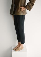 Women's dark beige leather moccasins with chain BUTYD-0914A-1B(W26), diagonal view of the product on the model's feet.