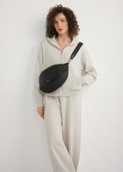 Large black women's waist bag TOREN-0345-99(W26) - front view of the product, on a model, against a light background. The entire silhouette is visible.