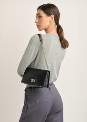 Black small women's handbag TOREC-1282-99(Z26), diagonal view of the product on the model. Half of the silhouette visible.