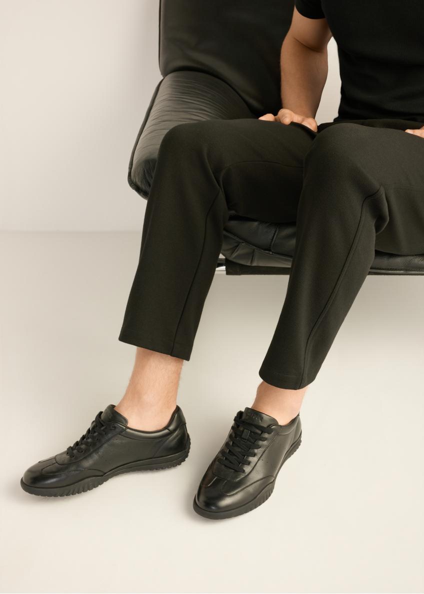 Black leather men's sports shoes BUTYM-0560-99(Z26) - side view of the product, on the model's feet, on a light background.