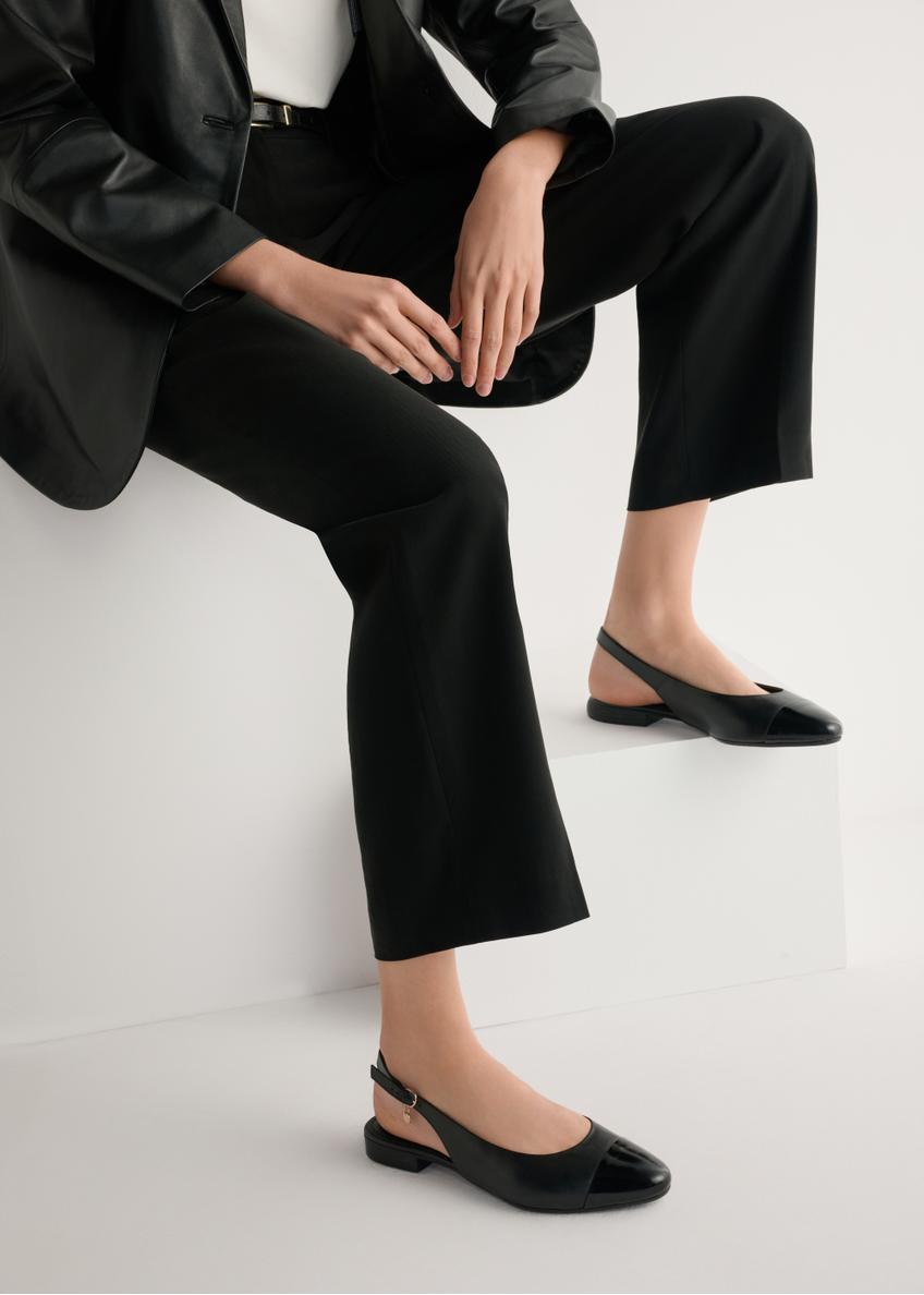 Black leather ballet flats without a heel BUTYD-1052A-99(W26), side view of the product on the model, half of the silhouette visible.