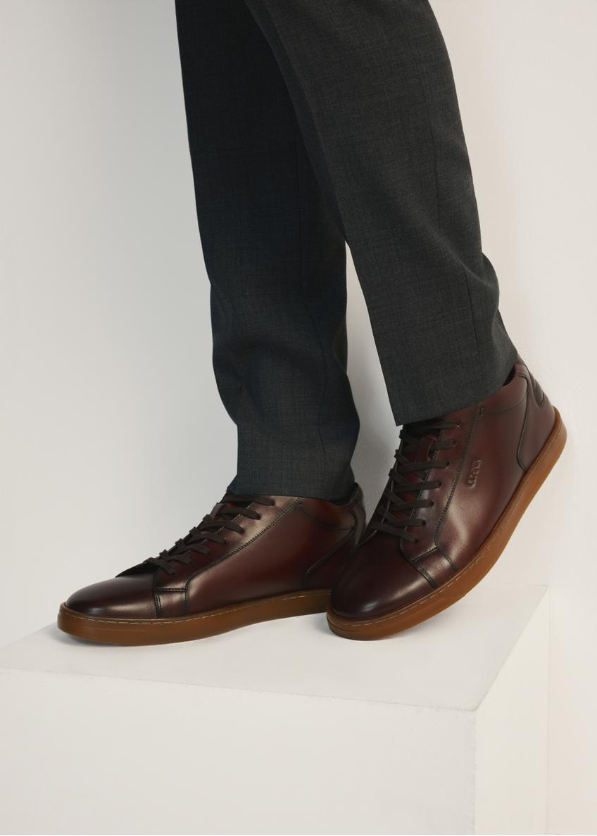 Brown men's leather sneakers BUTYM-0405B-89(Z25), side view of the product on the model, half of the silhouette visible.