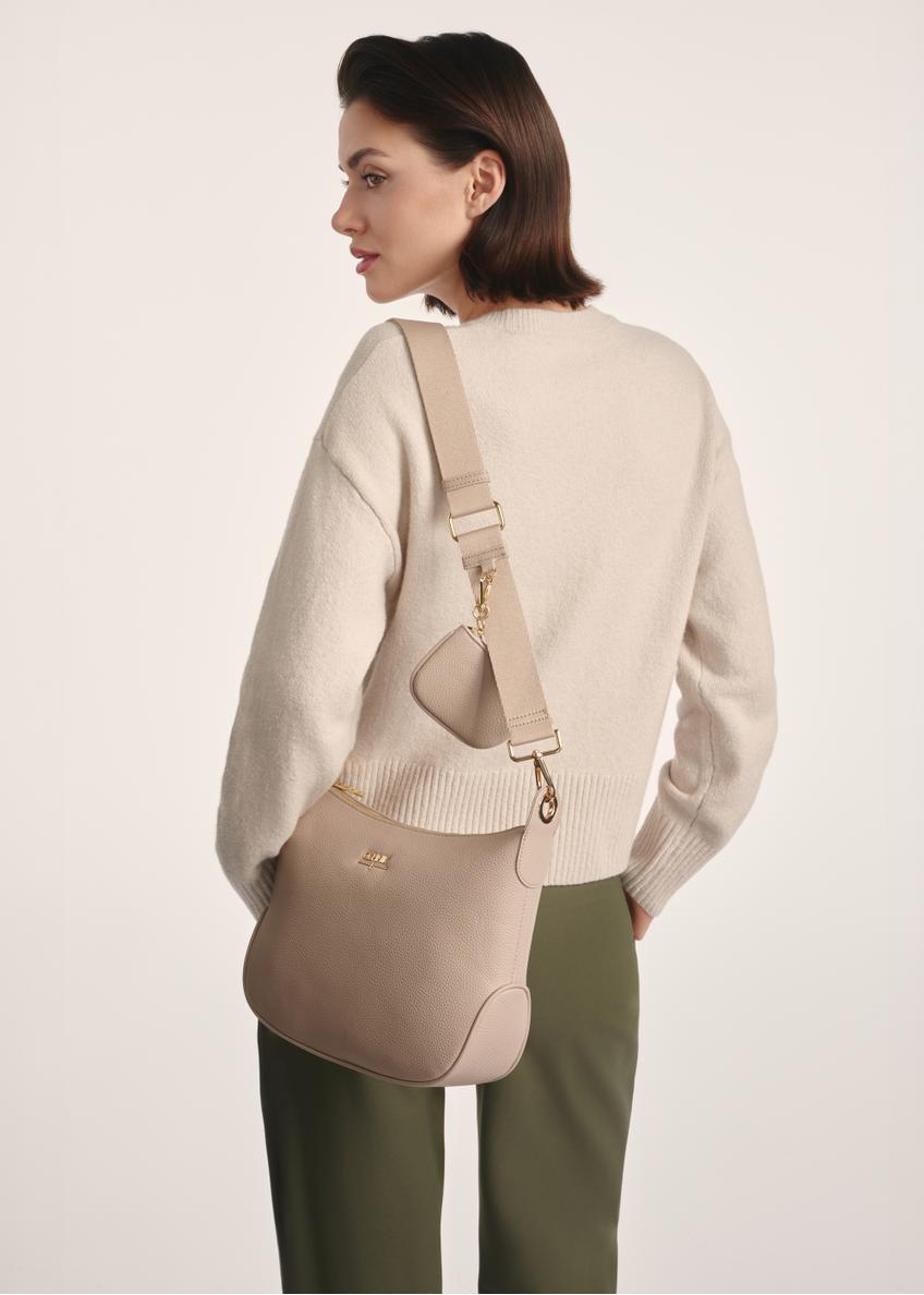 Beige women's hobo-style handbag TOREC-0829 A-80(Z 25), product view on model's shoulder. Half of silhouette visible.