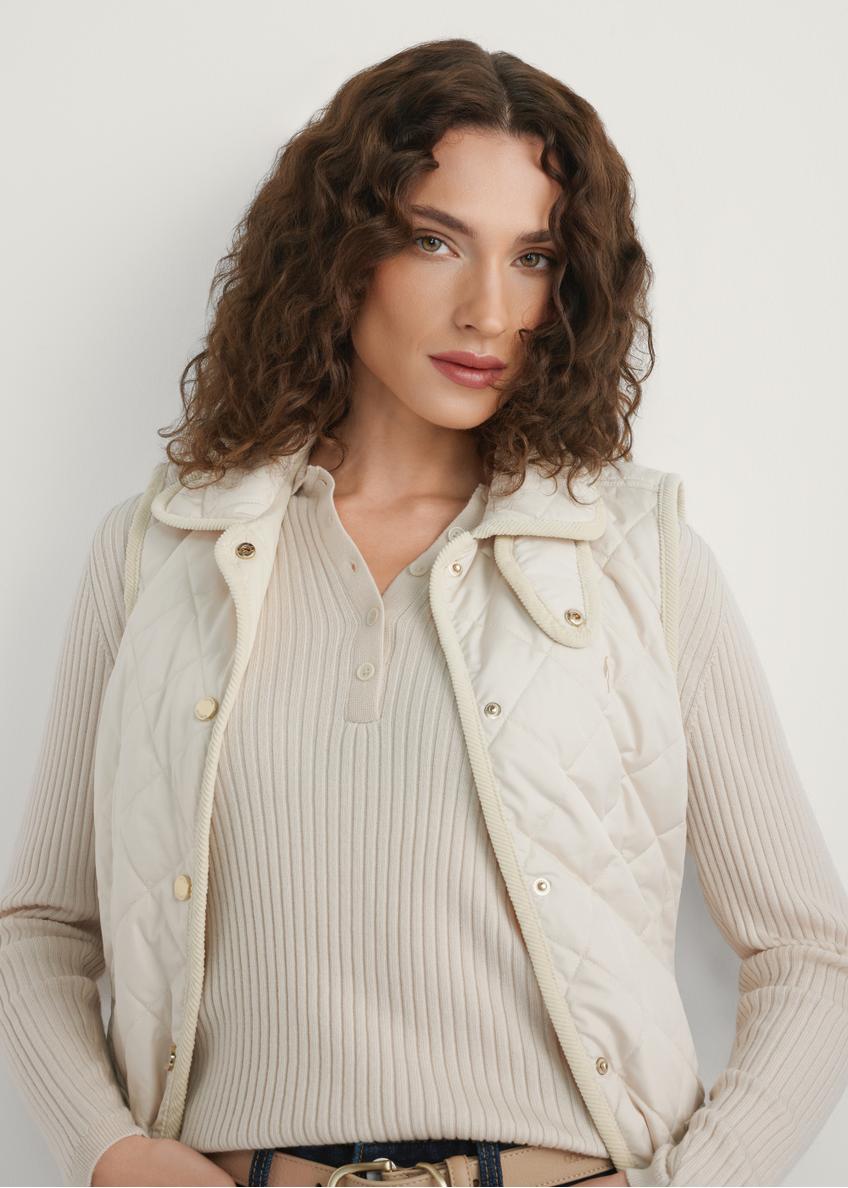 Light beige women's quilted vest KAMDT-0036-0B(W26) - front view of the product, on a model, against a light background. Half of the silhouette visible.