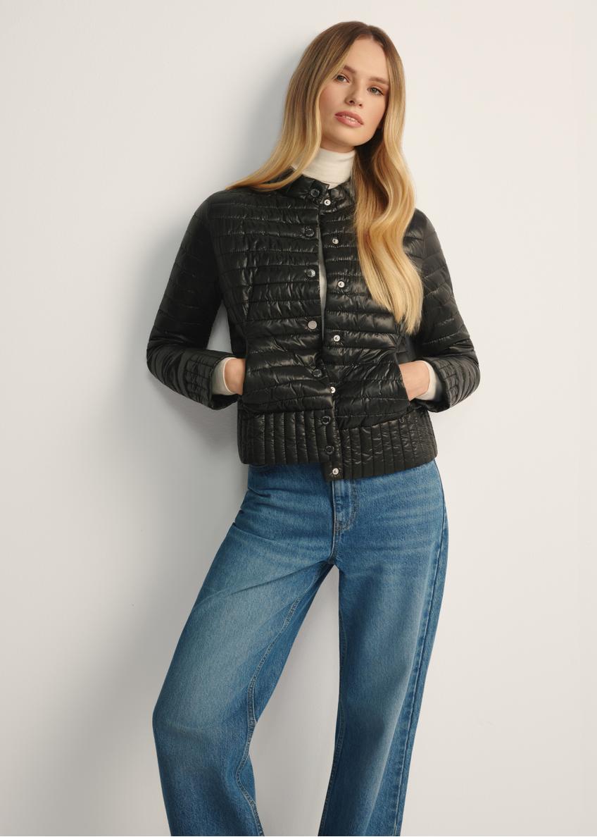 Black women's quilted jacket with a stand-up collar KURDT-0441-99(Z25), front view of the product on a model, half of the silhouette visible.-02