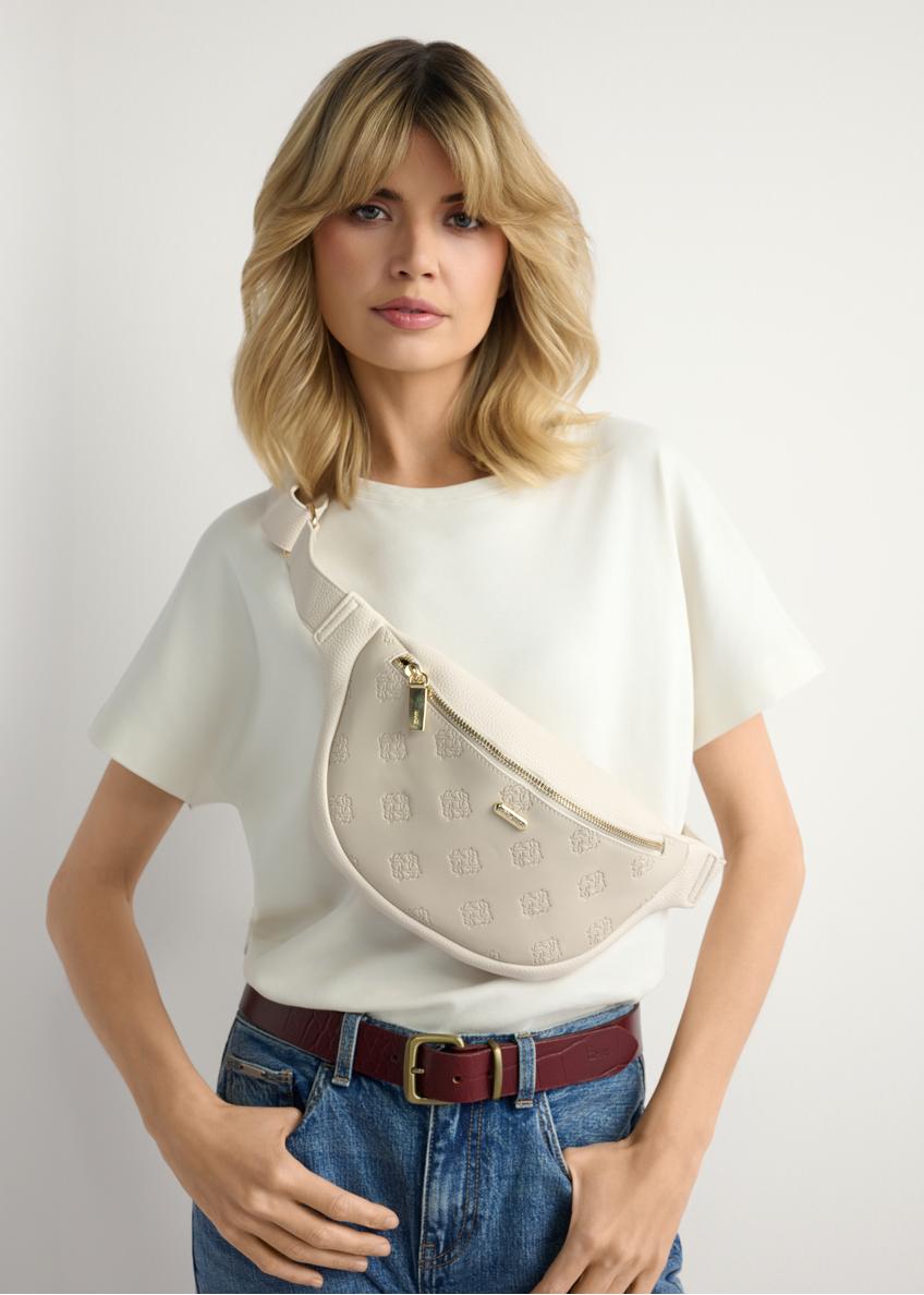 Women's cream monogram waist bag TOREC-1158-0B(W26), front view of the product on the model. Half of the silhouette visible.