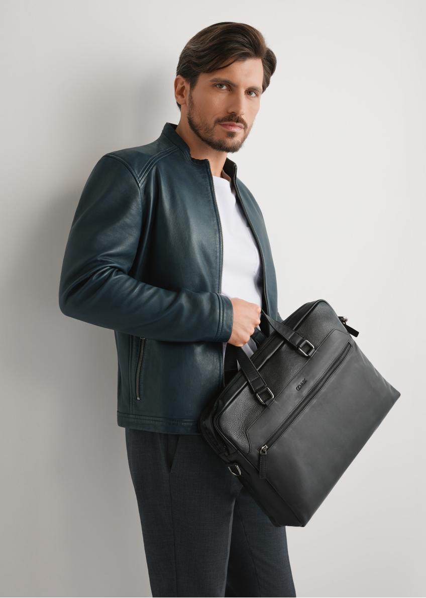 Black leather men's briefcase TORMS-0495-99(W26) - front view of the product, held by the model, against a light background. Half-length silhouette visible.