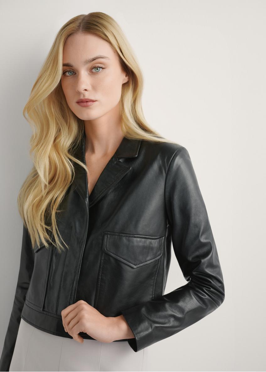 Black women's leather short jacket KURDS-0471-99(W26), close-up of the product on the model. Half of the silhouette visible.