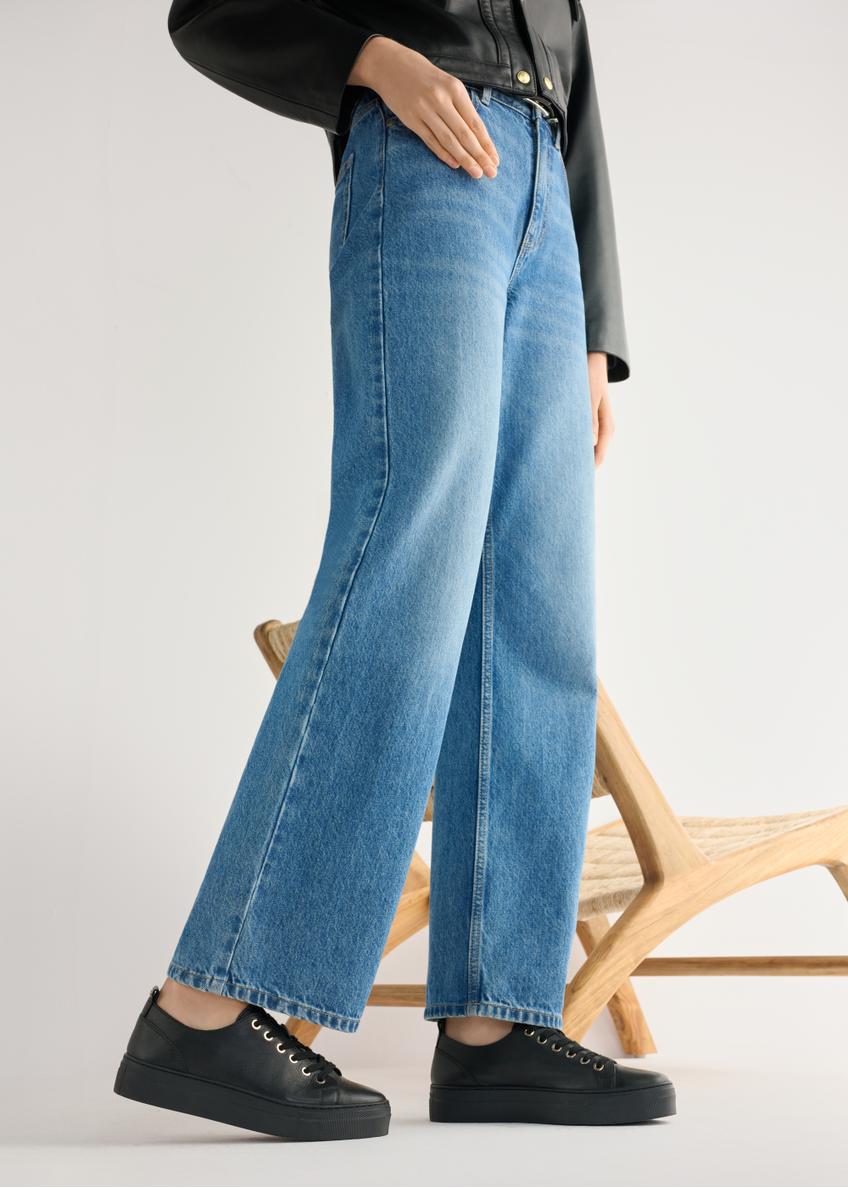 Women's high-top black leather sneakers BUTYD-1062-99(W26) - side view of the product, on a model, against a light background. Knee-length silhouette visible.