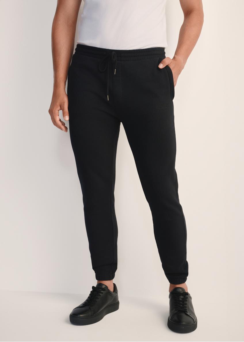 Black men's sweatpants SPOMT-0101-99(Z25), product view from the front on the model, half of the silhouette visible.