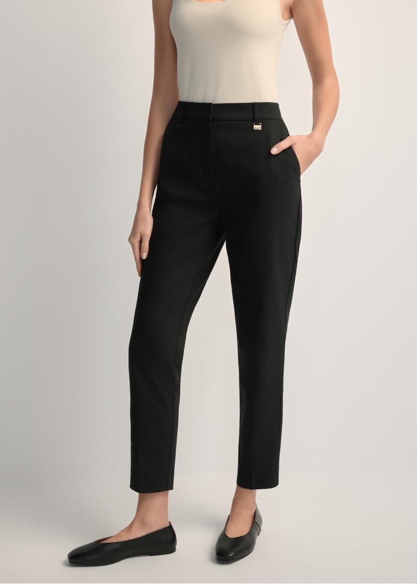 Women's black pleated trousers SPODT-0090-99(W25), front view of the product on the model. Half of the silhouette visible.