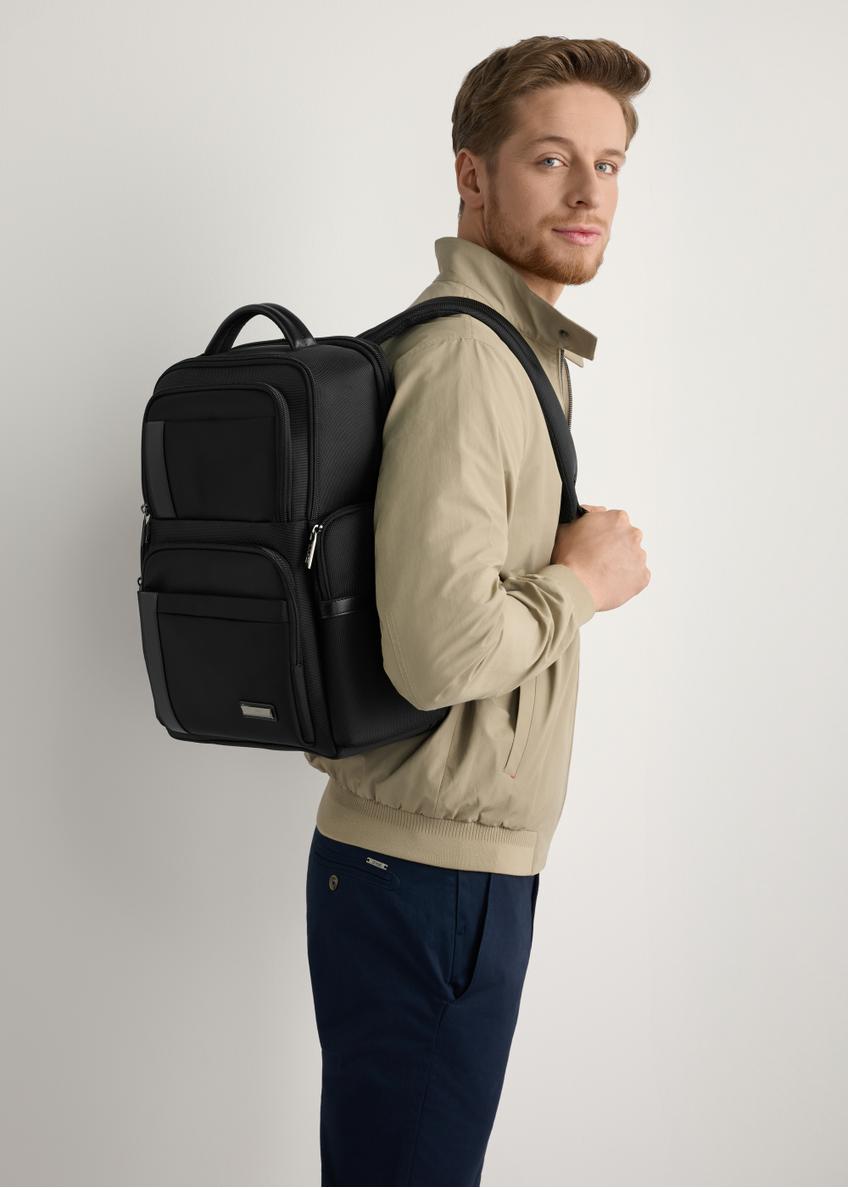 Black men's backpack TORMN-0406-99(W26), diagonal view of the product on the model's silhouette.