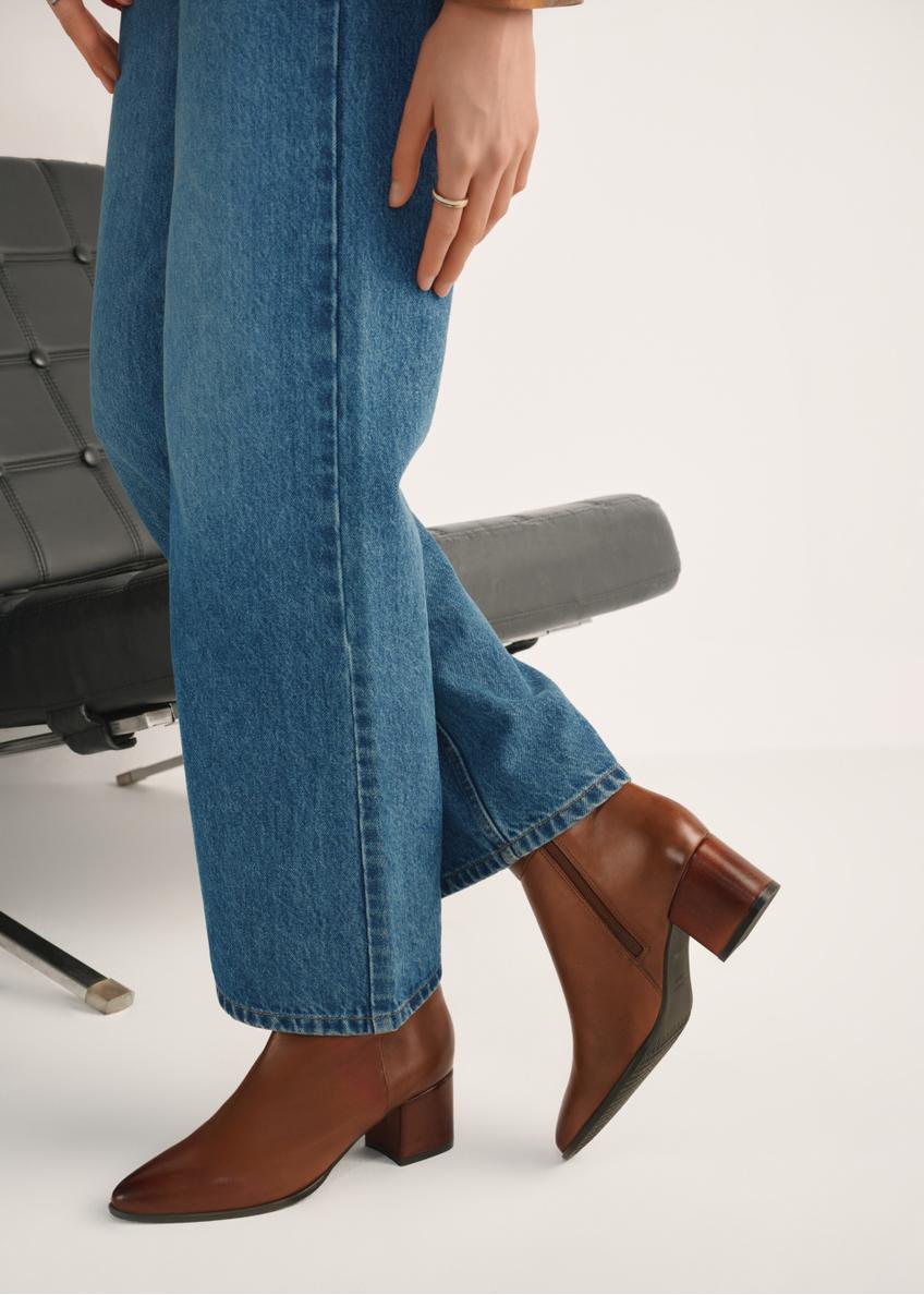 Women's leather ankle boots in cognac color BUTYD-1186-87(Z25), product view on a model against a light background.