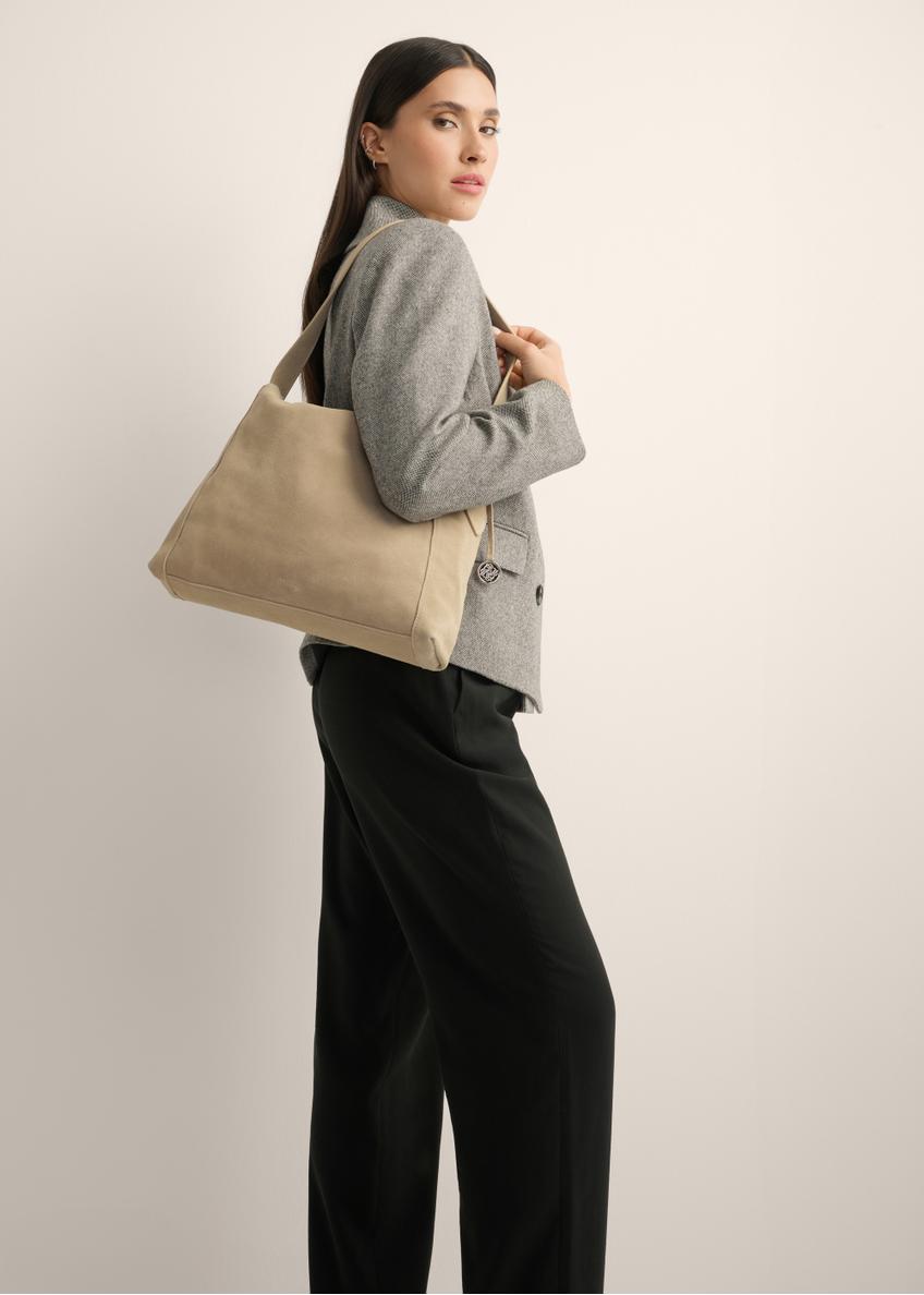Cool beige suede shoulder bag TORES-1406-1K(Z26) - view of the product held by the model on her shoulder, against a light background. The entire silhouette is visible.