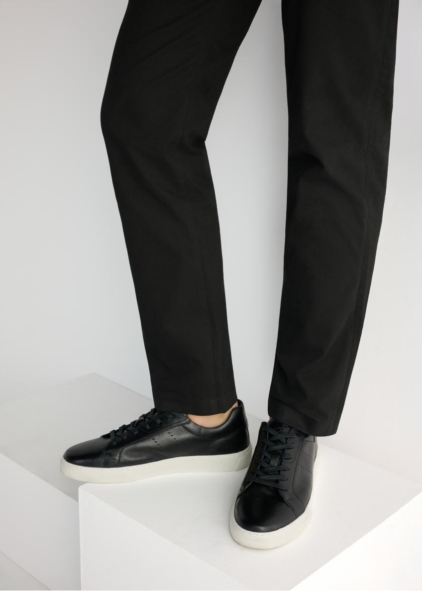 Black men's leather sneakers BUTYM-0486-99(W26), side view of the product on the model, half of the silhouette visible.