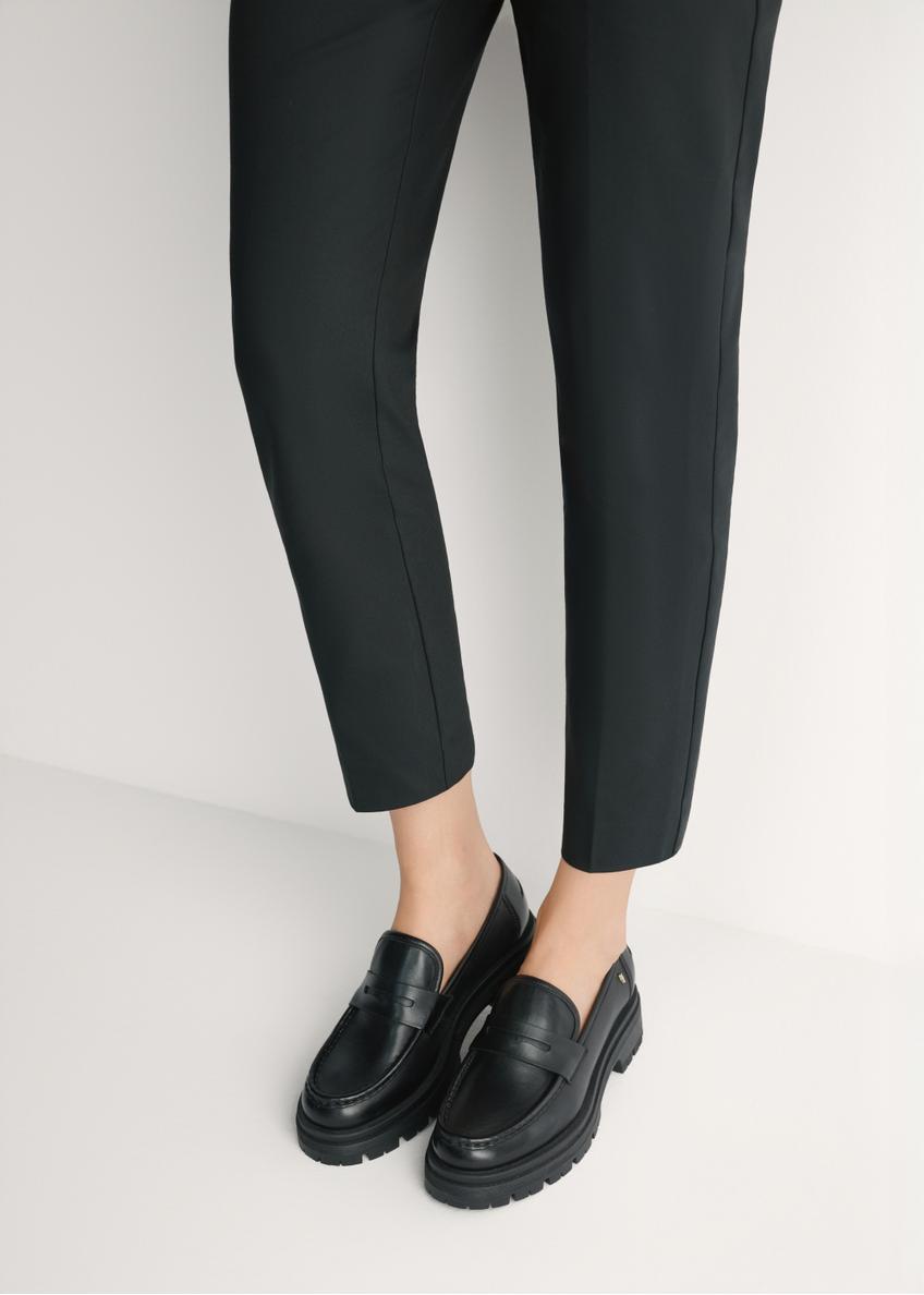 Women's black leather loafers BUTYD-1069-99(W26) - front view of the product, on a model, against a light background. Knee-length silhouette visible.