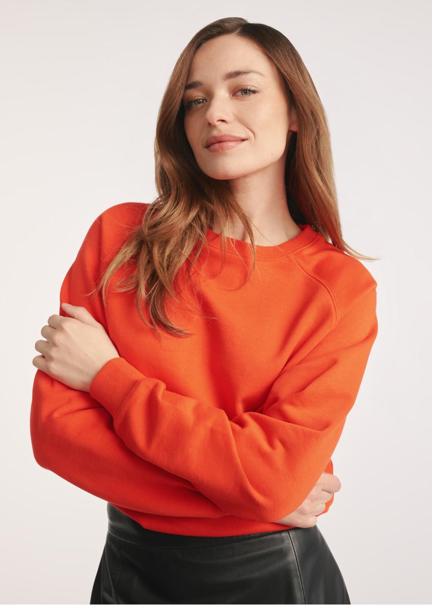 Orange women's sweatshirt BLZDT-0114-30(Z25) - close-up of the product on a model on a white background. Half of the silhouette visible.