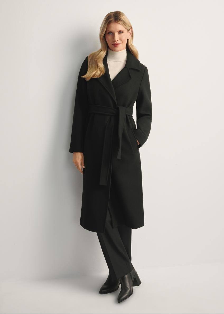 Black long women's coat PLADT-0048B-99(Z25), front view of the product on the model, the entire silhouette is visible.
