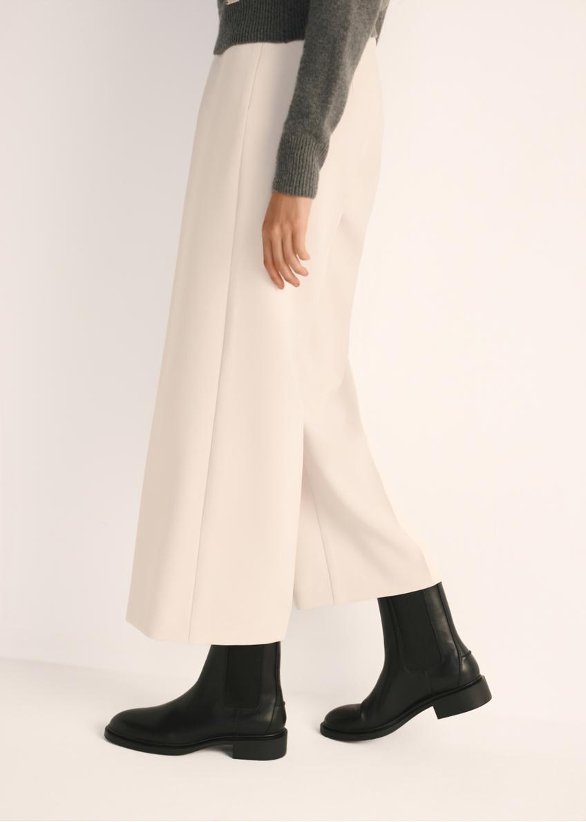 Black leather women's ankle boots BUTYD-1032-99(Z25), product view on model's feet against a light background.