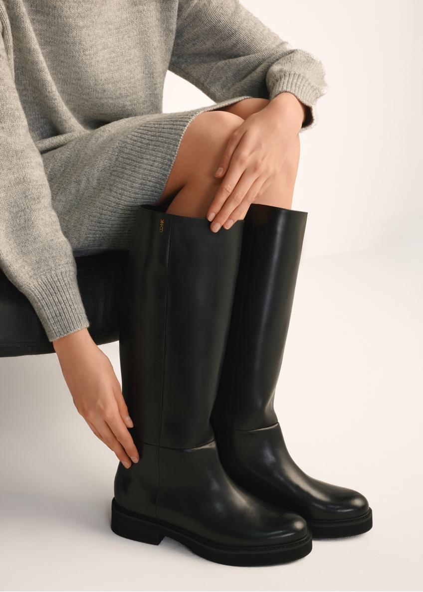 Women's leather boots in black BUTYD-1195-99(Z25), side view of the product on the model's feet.