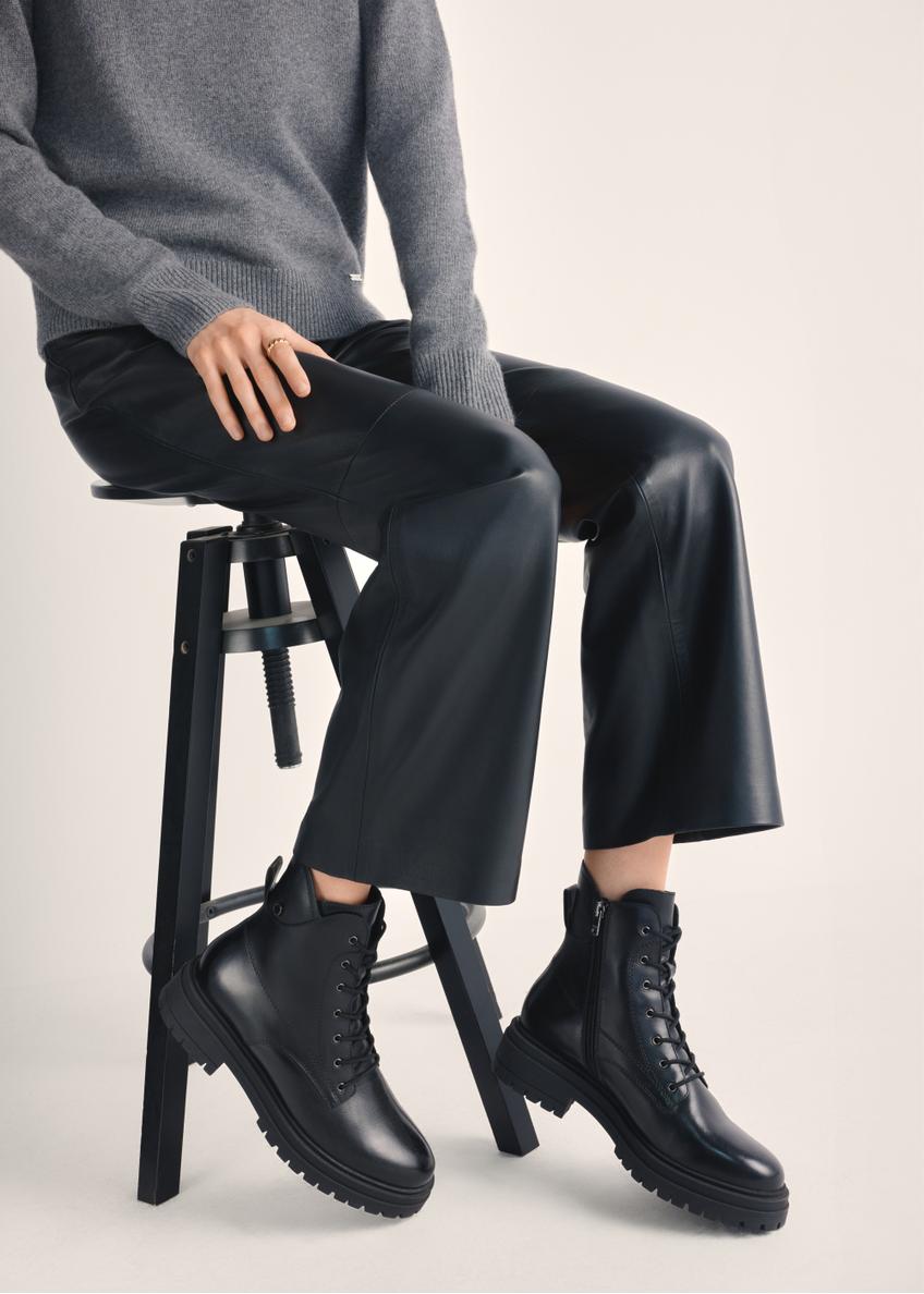 Black leather ankle boots BUTYD-1104-99(Z25), product view on model's feet against a light background.
