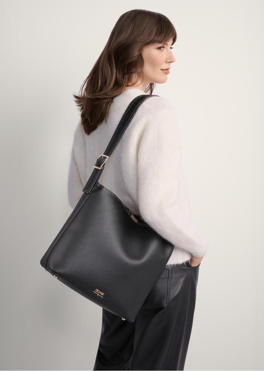Black women's shoulder bag TOREC-1062-99(Z25), front view of the product on a model, half of the silhouette visible.